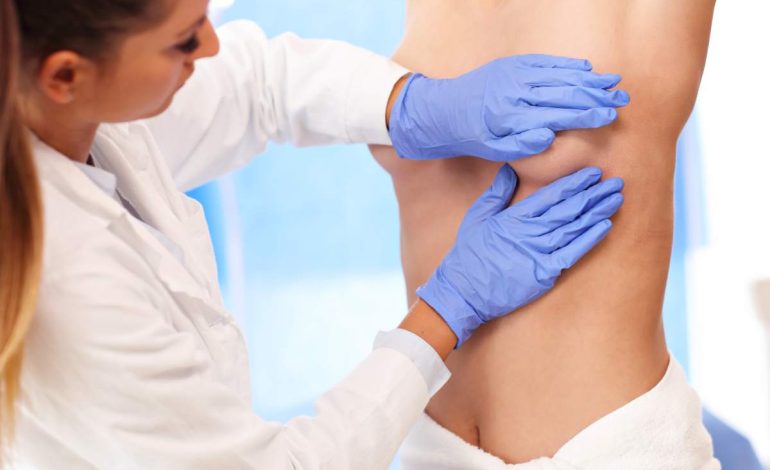 Picture of female doctor examining breast before breast lift surgery procedure